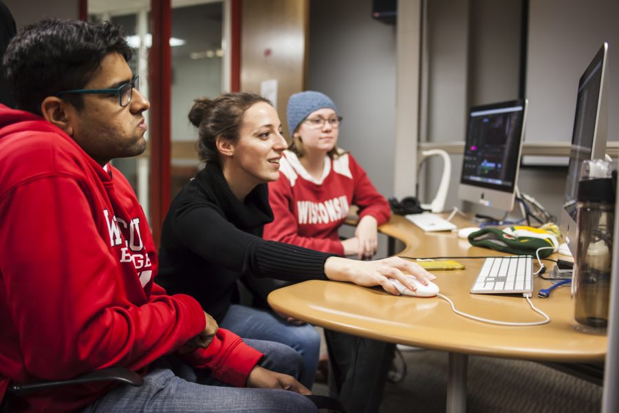 Teaching assistant Caroline Leader helps two undergraduate students as they edit video projects in the Hamel Lab.